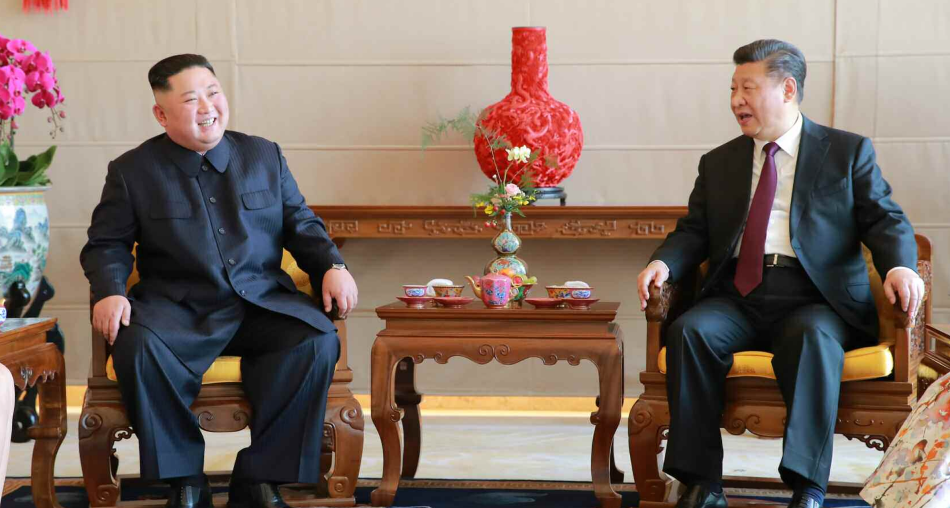 Kim Jong Un standing during his diplomatic visit to China.